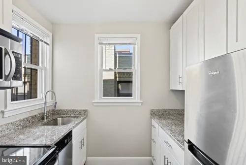 3742 12th Street Northeast, Unit 4 Washington, DC 20017 - Photo 5 of 8 a kitchen with stainless steel appliances granite countertop a sink and a refrigerator