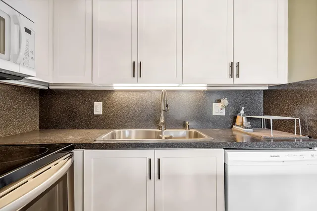 a kitchen with granite countertop a sink and a stove