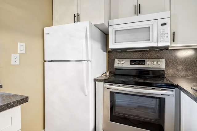 a white stove top oven sitting inside of a kitchen