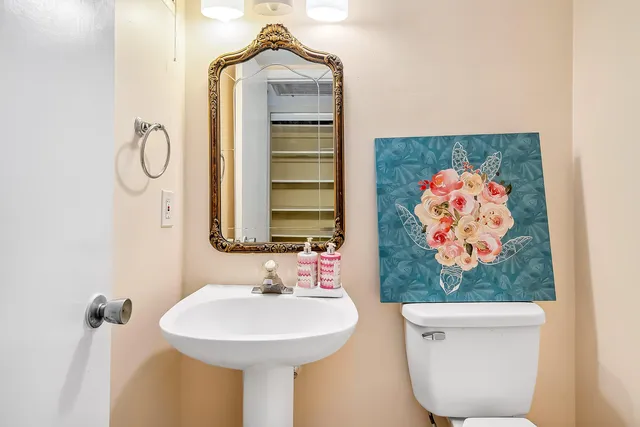 a bathroom with a sink mirror and toilet