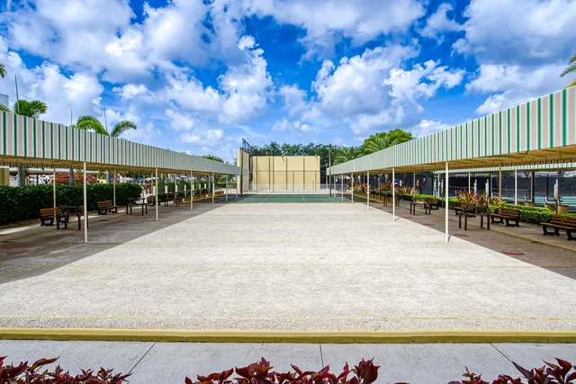 a view of swimming pool with seating area and trees in the background