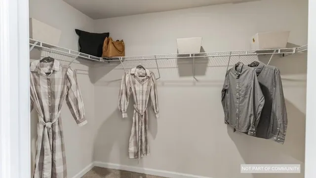 a bed sitting in a spacious bedroom next to a window