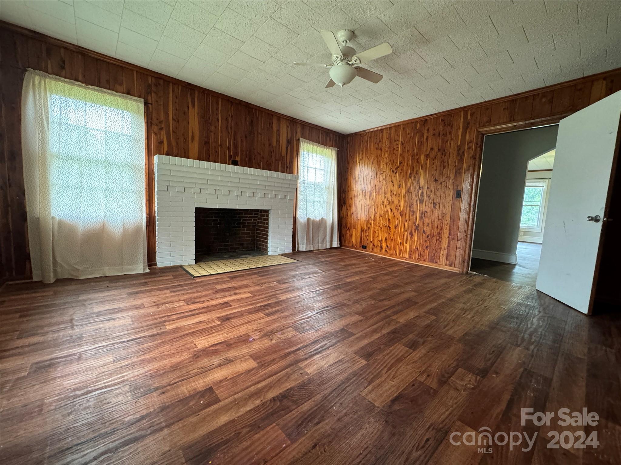 1555 Lower Palmer Road Rockwell, NC 28138 - Photo 14 of 17 an empty room with wooden floor fireplace and windows