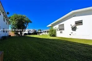 a view of a backyard with plants and a tree