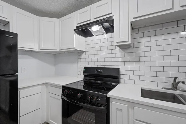 a room with a chandelier fan and wooden floor