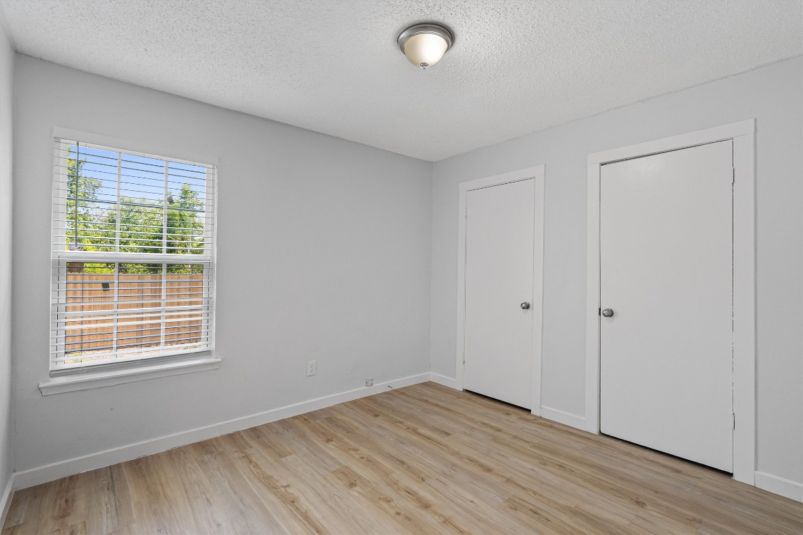 520 Lenora Drive, Unit A Taylor, TX 76574 - Photo 13 of 24 a view of an empty room with wooden floor and a window