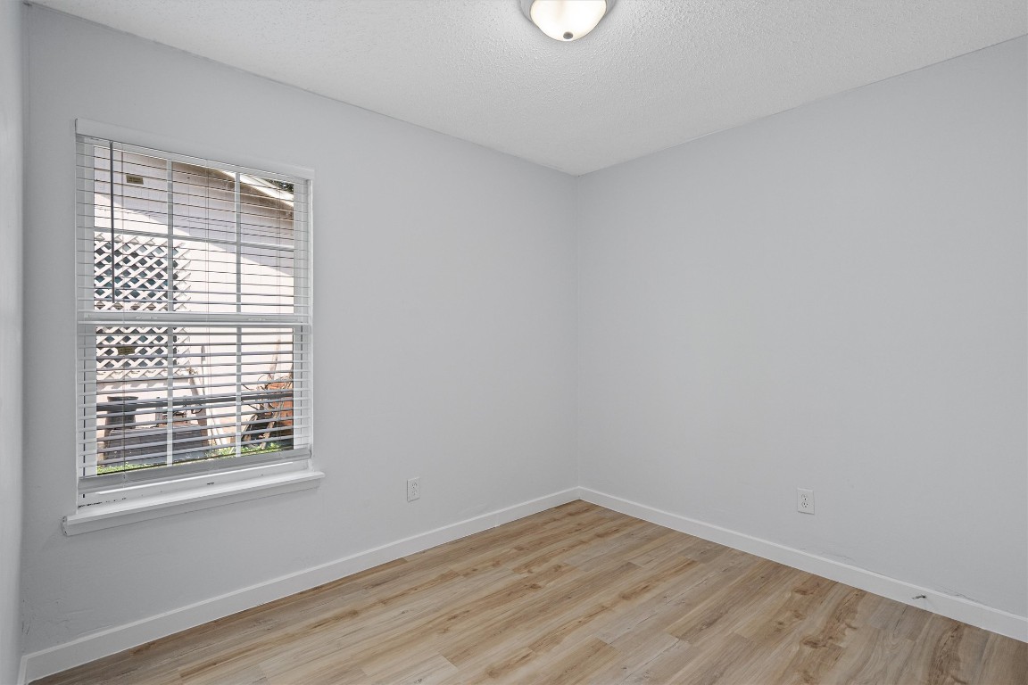 520 Lenora Drive, Unit A Taylor, TX 76574 - Photo 15 of 24 a view of an empty room with wooden floor and a window