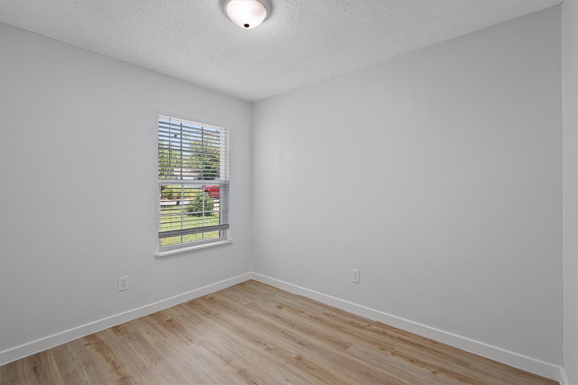 520 Lenora Drive, Unit A Taylor, TX 76574 - Photo 17 of 24 an empty room with wooden floor and windows