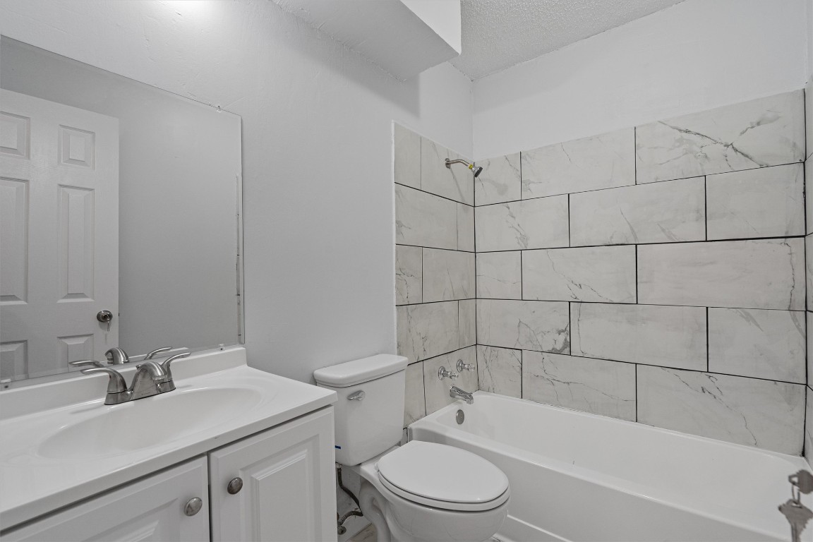 520 Lenora Drive, Unit A Taylor, TX 76574 - Photo 19 of 24 a bathroom with a bathtub shower sink mirror vanity and toilet