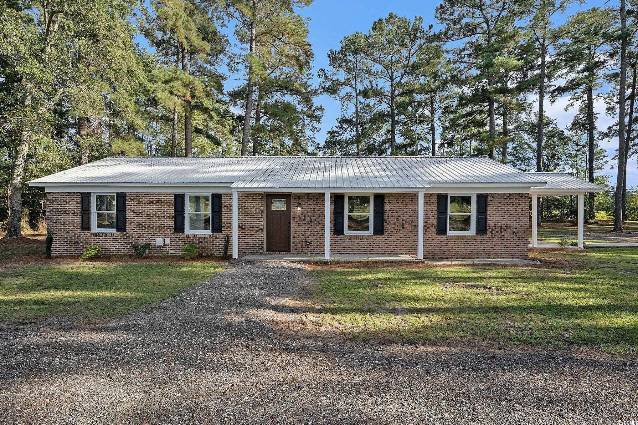 494 Ray Road Hemingway, SC 29554 - Photo 1 of 26 Ranch-style home featuring brick siding, a metal roof, a front yard, and covered porch