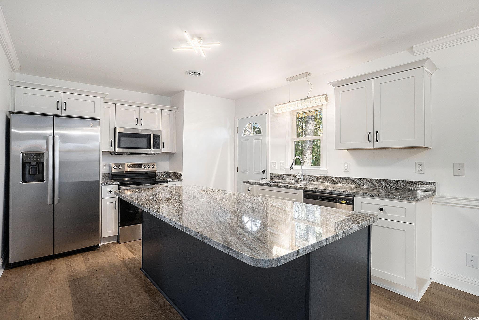 494 Ray Road Hemingway, SC 29554 - Photo 11 of 26 Kitchen with appliances with stainless steel finishes, dark stone countertops, a kitchen island, dark cabinetry, and white cabinets