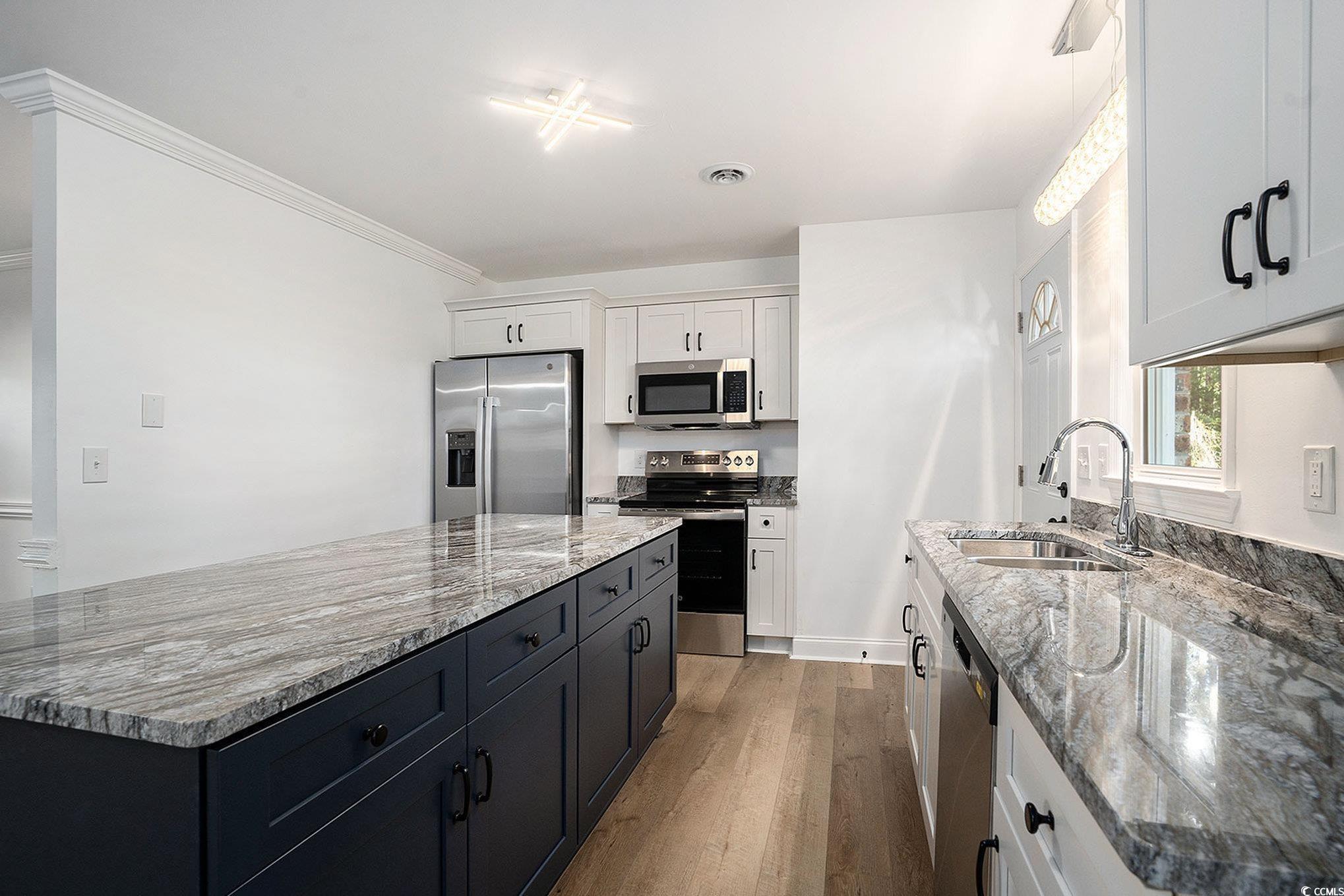 494 Ray Road Hemingway, SC 29554 - Photo 12 of 26 Kitchen featuring stainless steel appliances, dark wood-type flooring, light stone countertops, white cabinetry, and ornamental molding