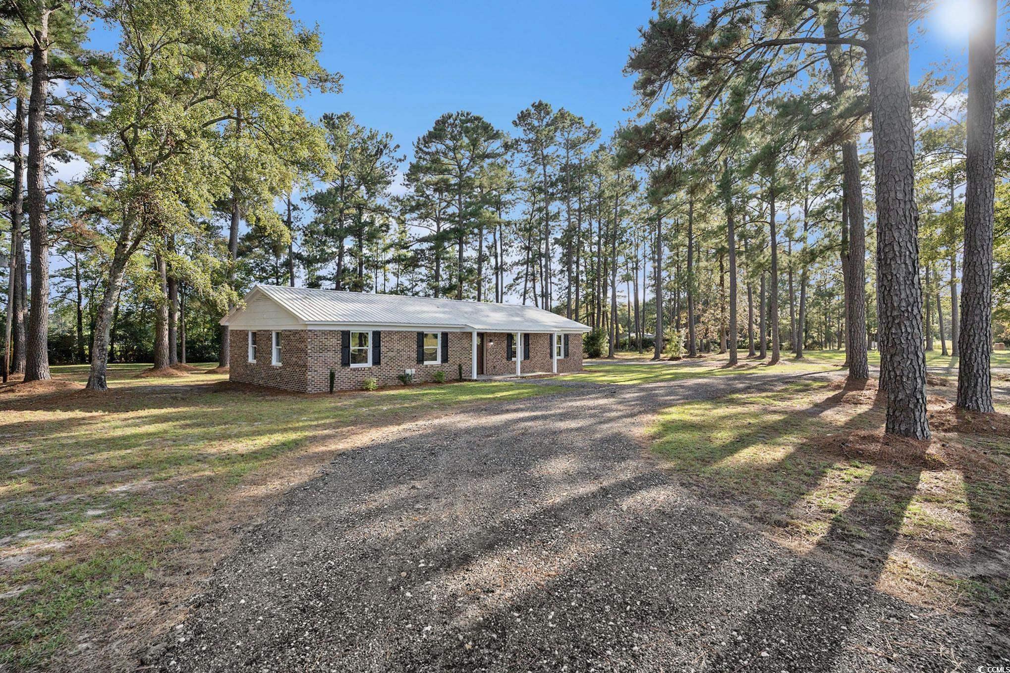 494 Ray Road Hemingway, SC 29554 - Photo 5 of 26 View of front of house with a metal roof, brick siding, gravel driveway, a front yard, and a porch
