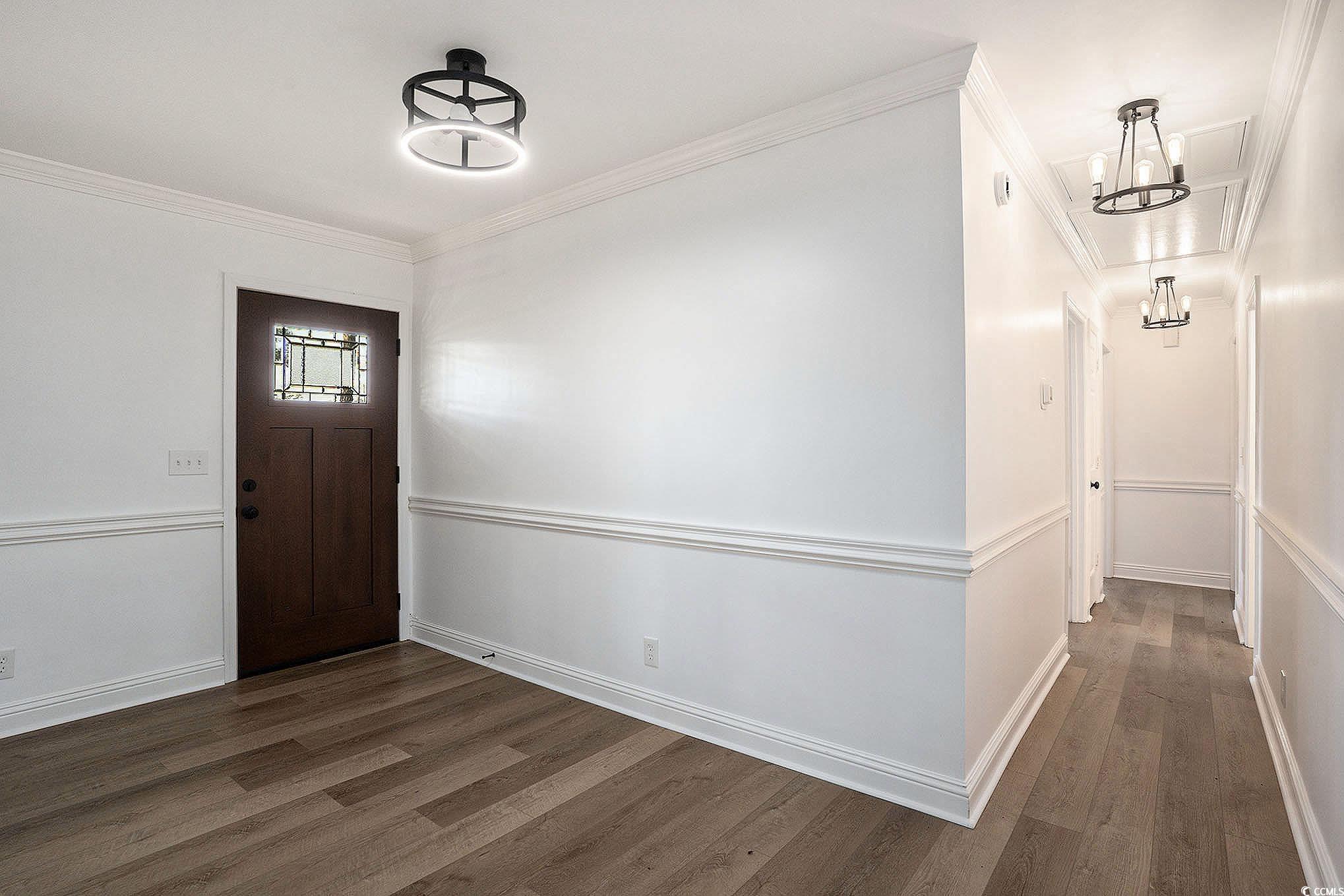 494 Ray Road Hemingway, SC 29554 - Photo 6 of 26 Entrance foyer with crown molding, dark wood-style flooring, and a chandelier