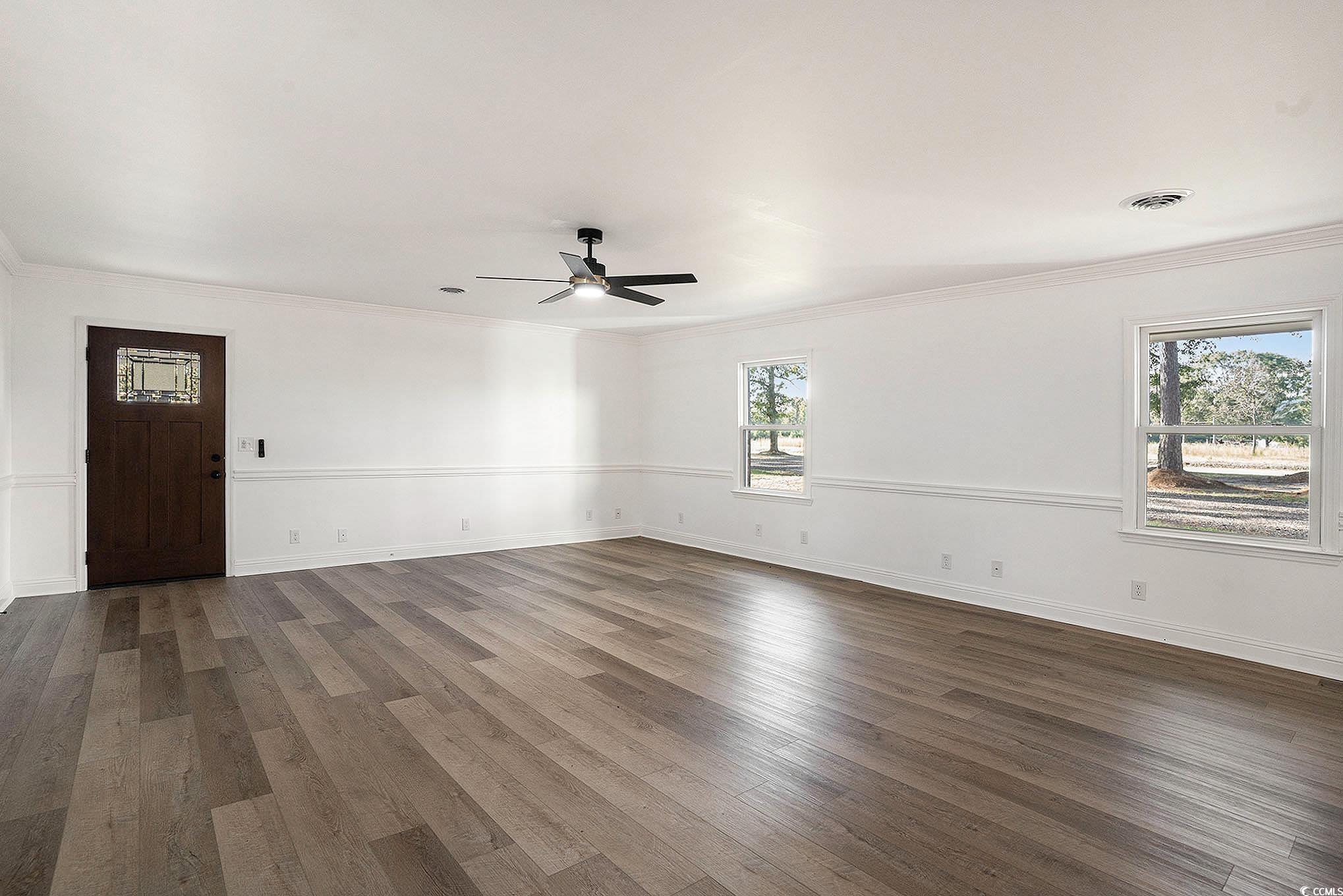 494 Ray Road Hemingway, SC 29554 - Photo 7 of 26 Unfurnished room featuring dark wood-type flooring, crown molding, and a ceiling fan