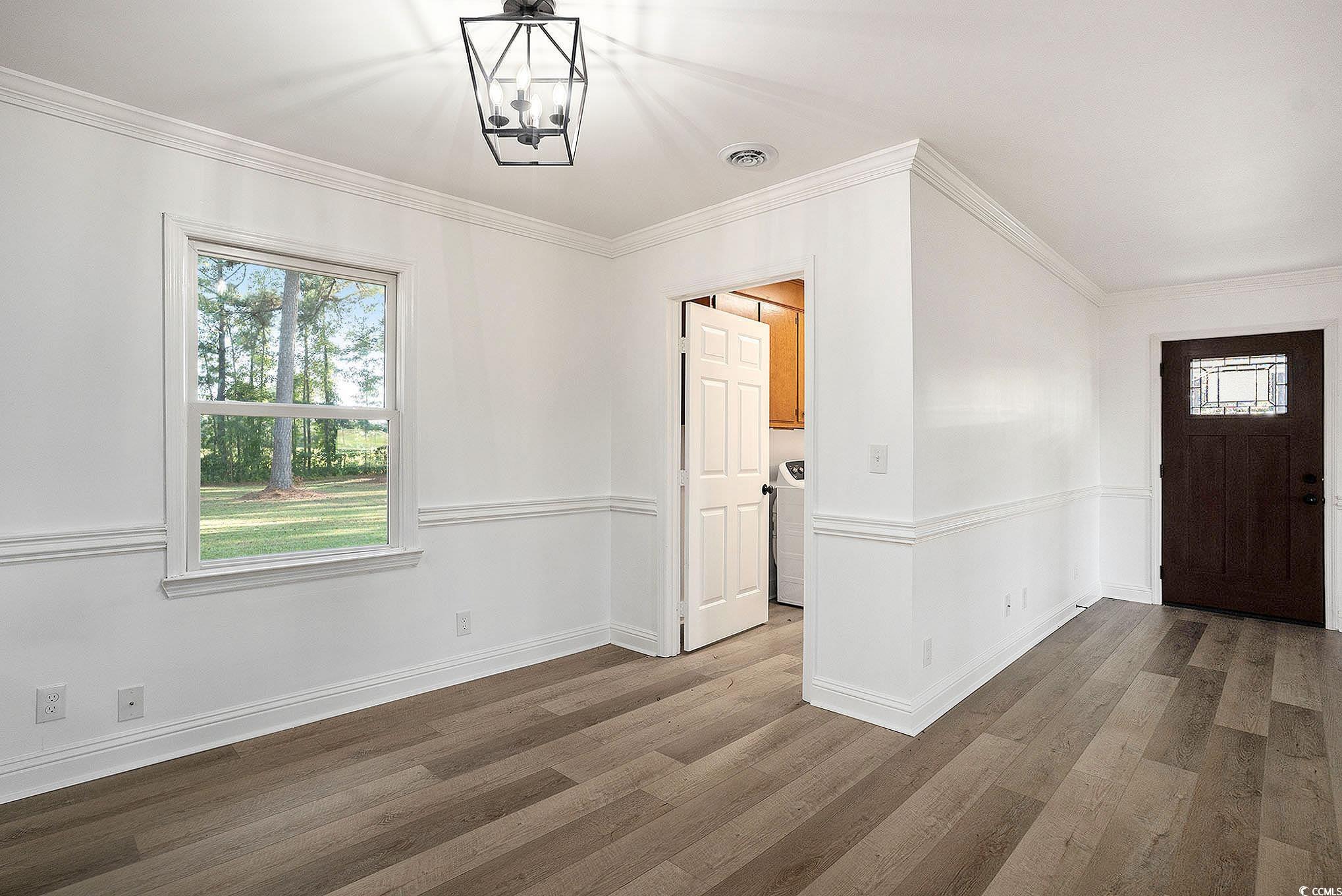 494 Ray Road Hemingway, SC 29554 - Photo 10 of 26 Entrance foyer featuring wood finished floors, ornamental molding, healthy amount of natural light, and a chandelier