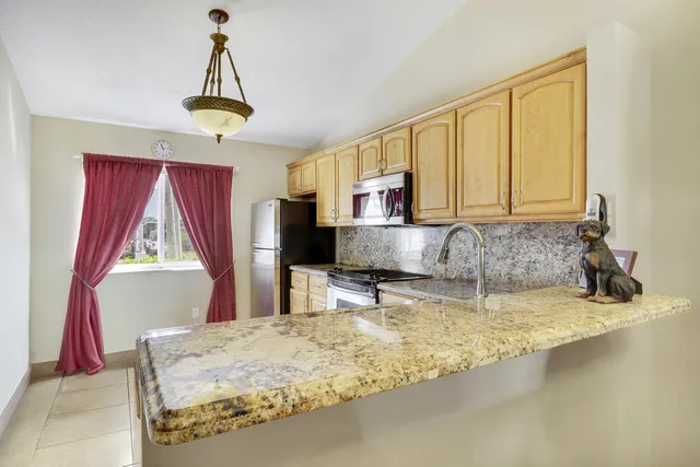 a kitchen with a stove a refrigerator and a sink