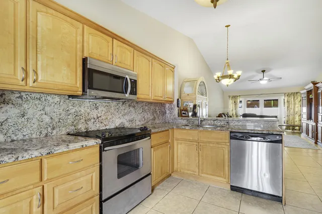 a kitchen with stainless steel appliances granite countertop a sink and stove top oven