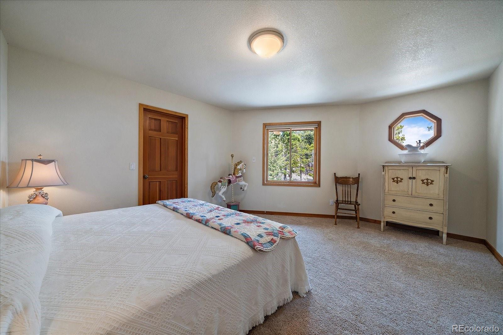 19791 Maxwell Drive Morrison, CO 80465 - Photo 17 of 50 a bedroom with a bed and a window