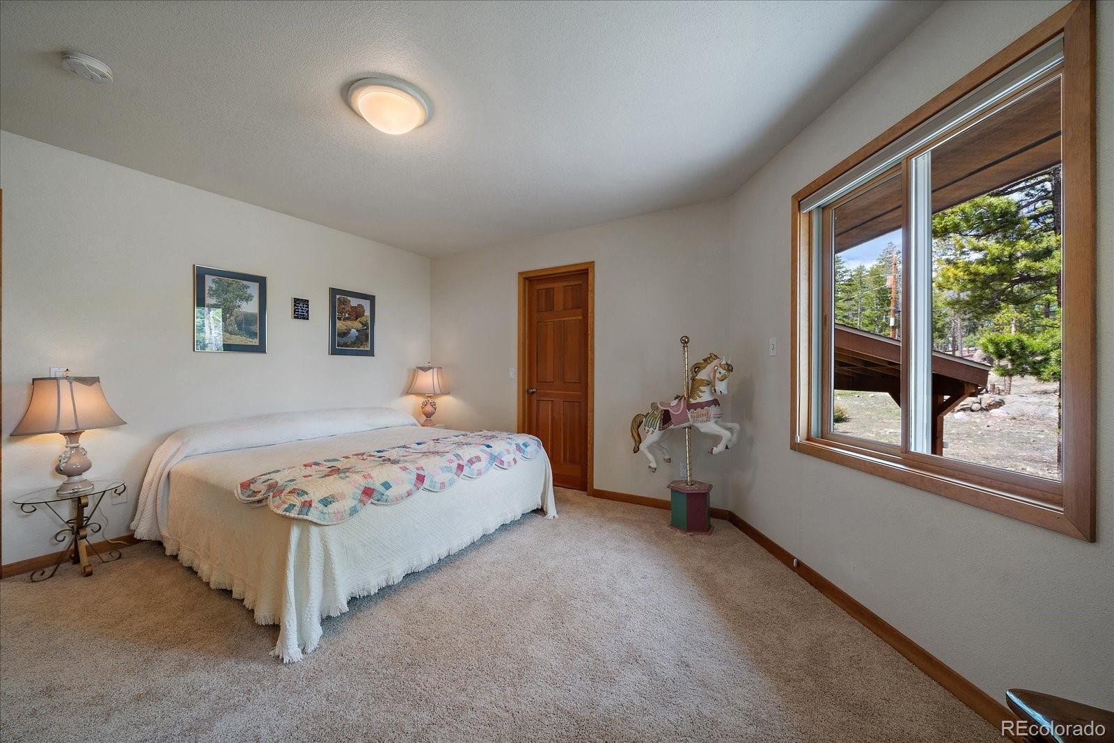 19791 Maxwell Drive Morrison, CO 80465 - Photo 18 of 50 a bedroom with a bed and a large window