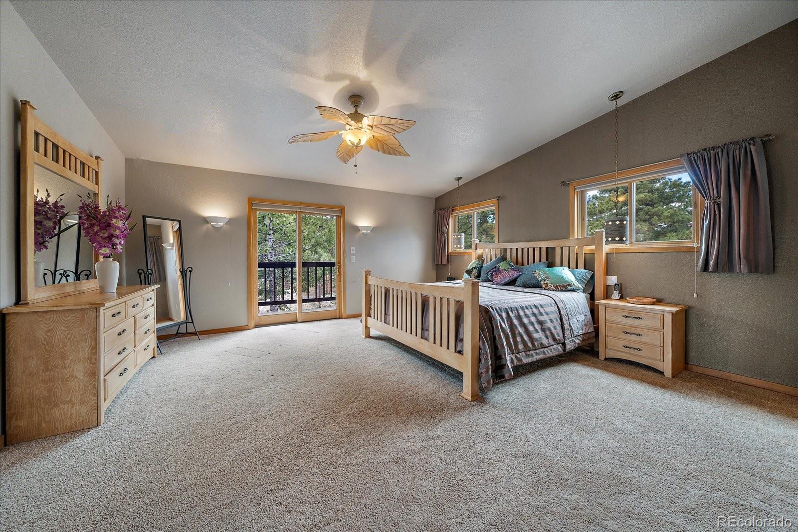 19791 Maxwell Drive Morrison, CO 80465 - Photo 30 of 50 a bed room with a bed and a chandelier