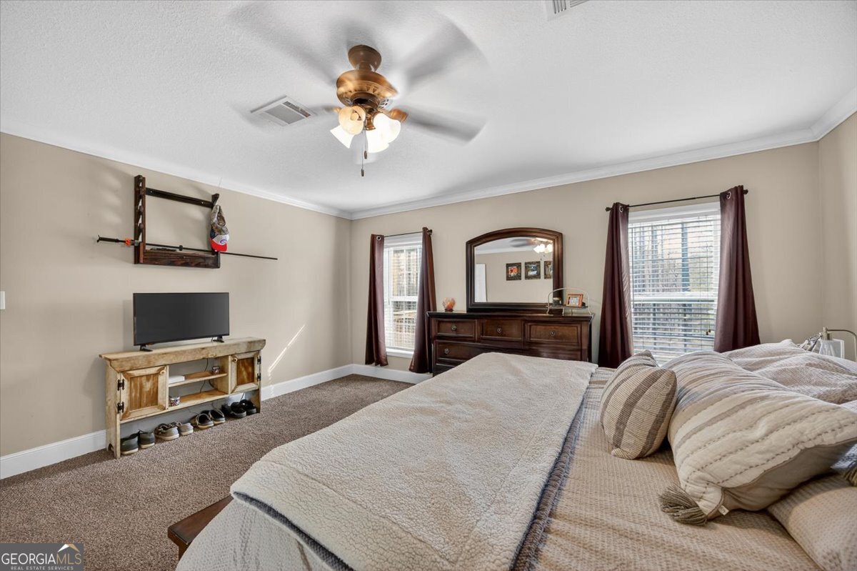 550 Damascus Church Road Haddock, GA 31033 - Photo 13 of 34 a bedroom with a bed and a chandelier