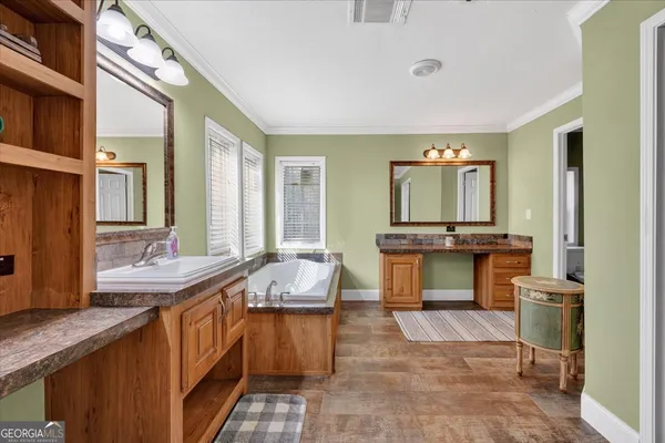a large bathroom with a large tub sink and mirror