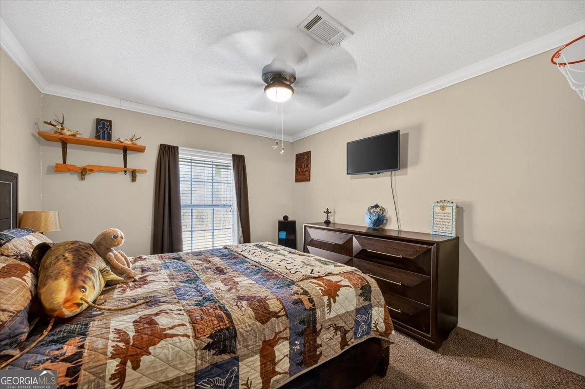 550 Damascus Church Road Haddock, GA 31033 - Photo 22 of 34 a bedroom with a bed and a flat screen tv