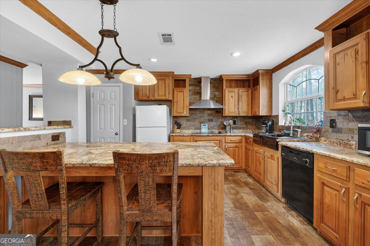 550 Damascus Church Road Haddock, GA 31033 - Photo 8 of 34 a kitchen with stainless steel appliances granite countertop a stove top oven a sink a dining table and chairs with wooden floor