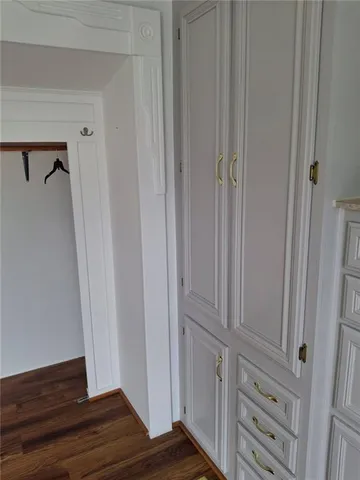 a view of a closet area with hardwood floor