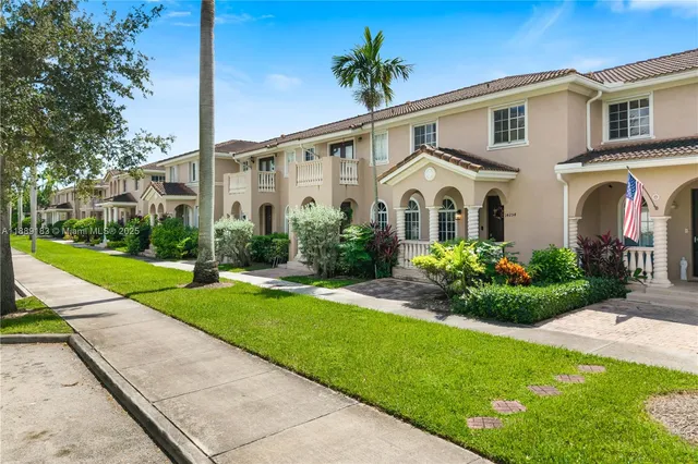 a front view of a house with a garden and plants