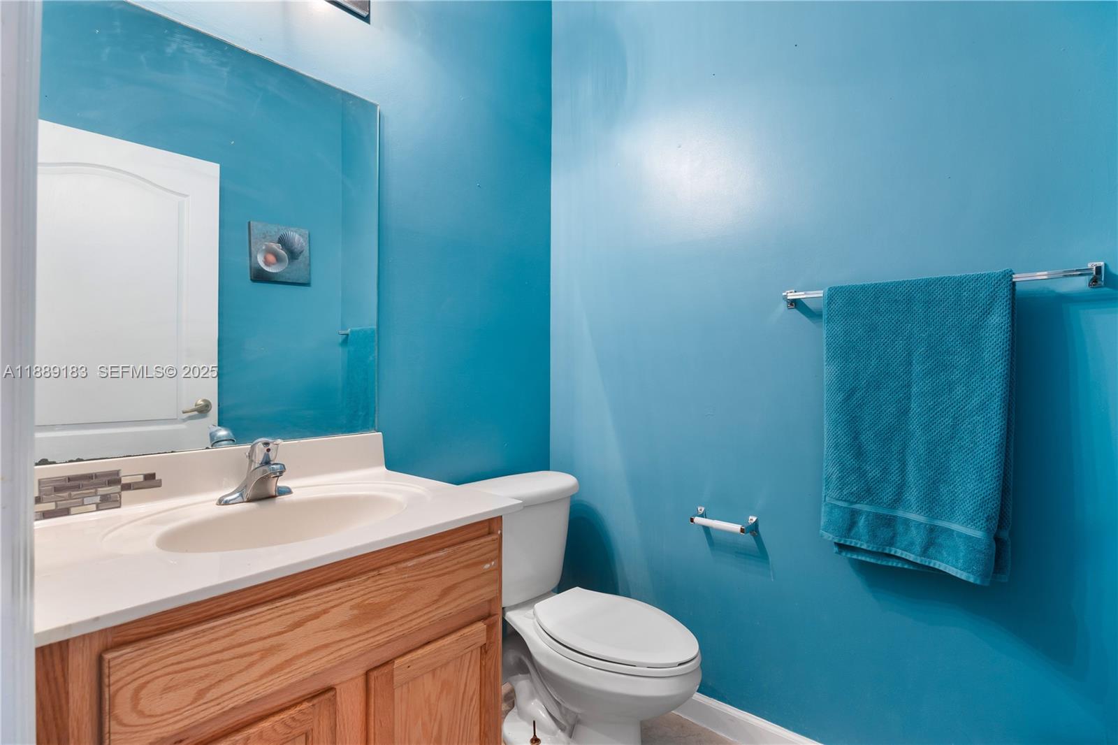 14254 Southwest 272nd Street Homestead, FL 33032 - Photo 5 of 25 a bathroom with a sink vanity mirror and toilet