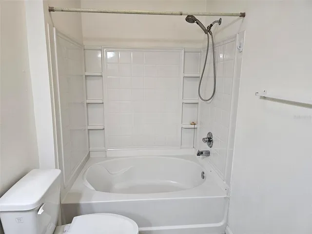 a white bath tub sitting next to a toilet