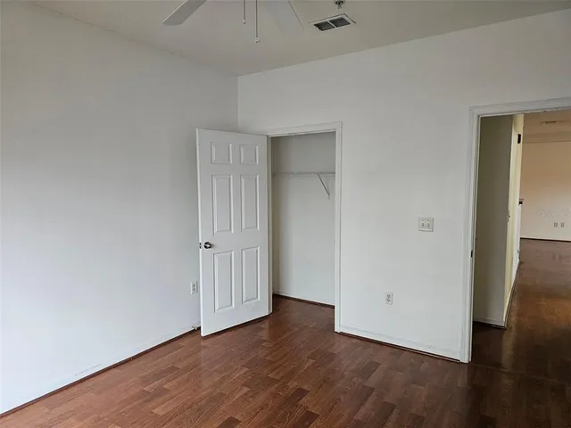 an empty room with wooden floor and closet