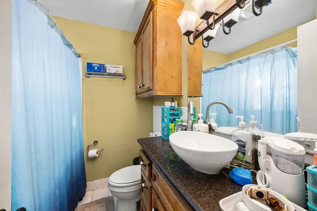 a bathroom with a granite countertop sink mirror vanity and toilet