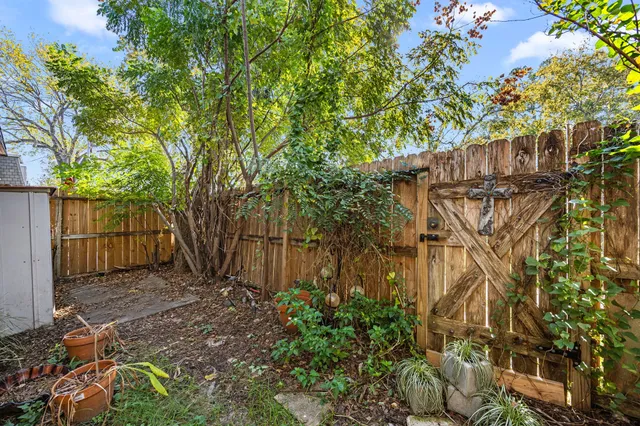 a view of a yard with plants and wooden fence