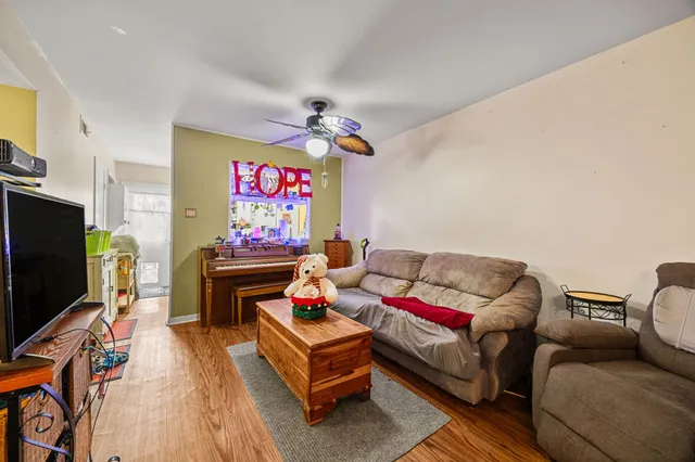 a living room with furniture a flat screen tv and a wall painting