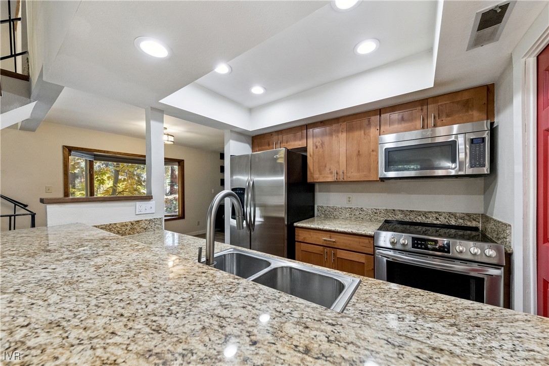908 Harold Drive, Unit 23 Incline Village, NV 89451 - Photo 5 of 44 a kitchen with stainless steel appliances granite countertop a stove a sink and a microwave