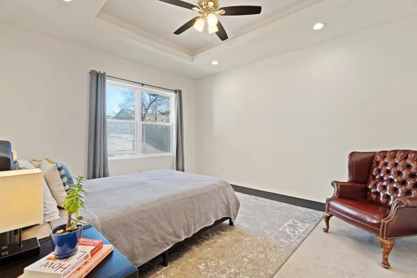 a spacious bedroom with a large bed and a chandelier
