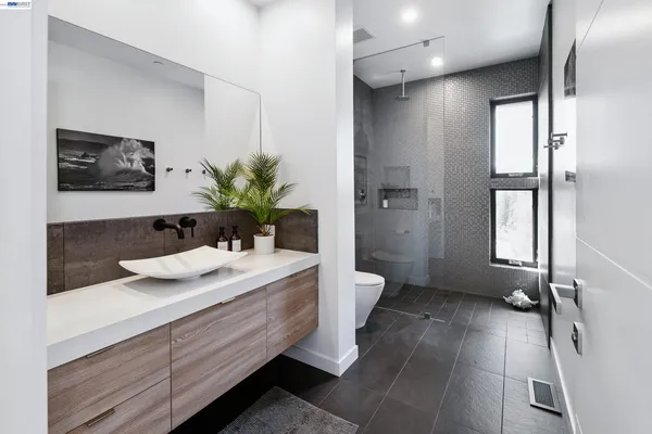 a bathroom with a sink a toilet and shower