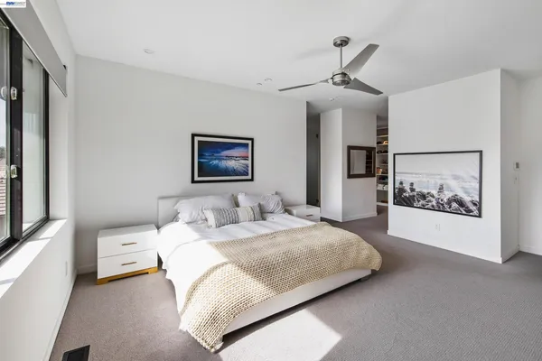 a spacious bedroom with a bed and a painting on the wall