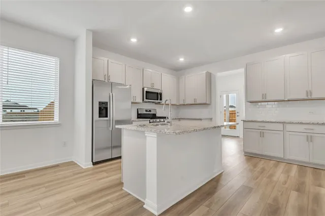 a kitchen with white cabinets and white appliances