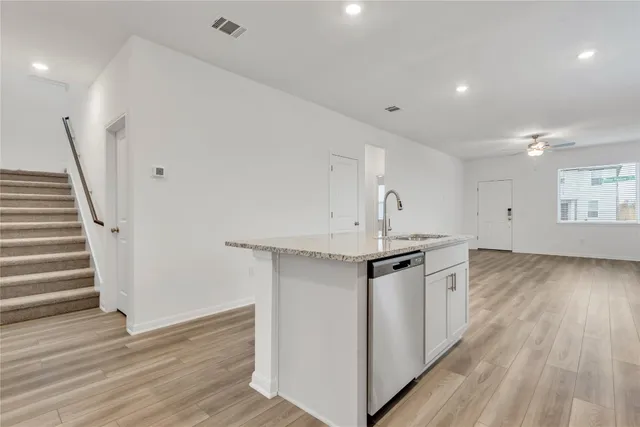 a kitchen with granite countertop a sink and a stove top oven