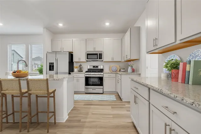 a kitchen with granite countertop white cabinets and white appliances