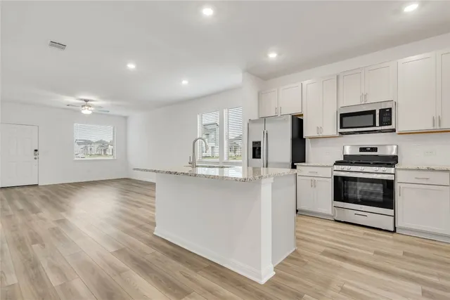 a kitchen with stainless steel appliances a refrigerator stove and microwave