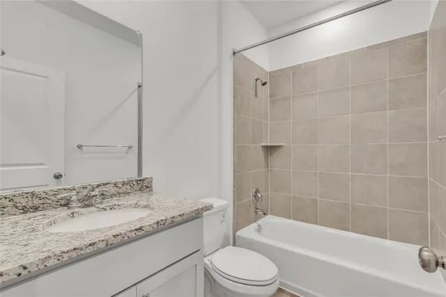 a bathroom with a granite countertop bathtub toilet sink and mirror