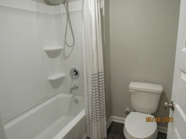a white toilet sitting next to a bath tub and a shower