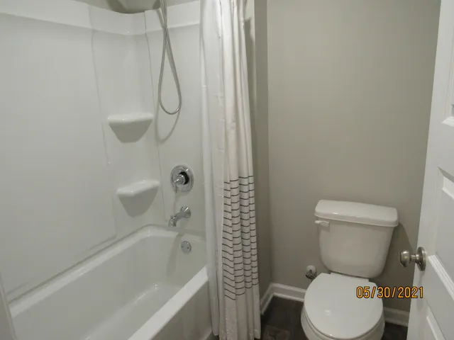 a white toilet sitting next to a bath tub and a shower