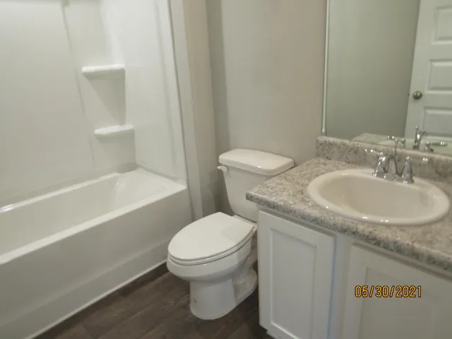 a bathroom with a granite countertop toilet a sink and bathtub