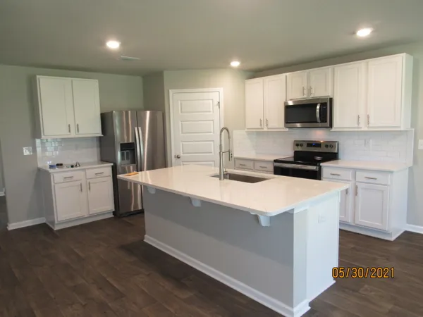 a kitchen with stainless steel appliances a sink stove refrigerator and cabinets
